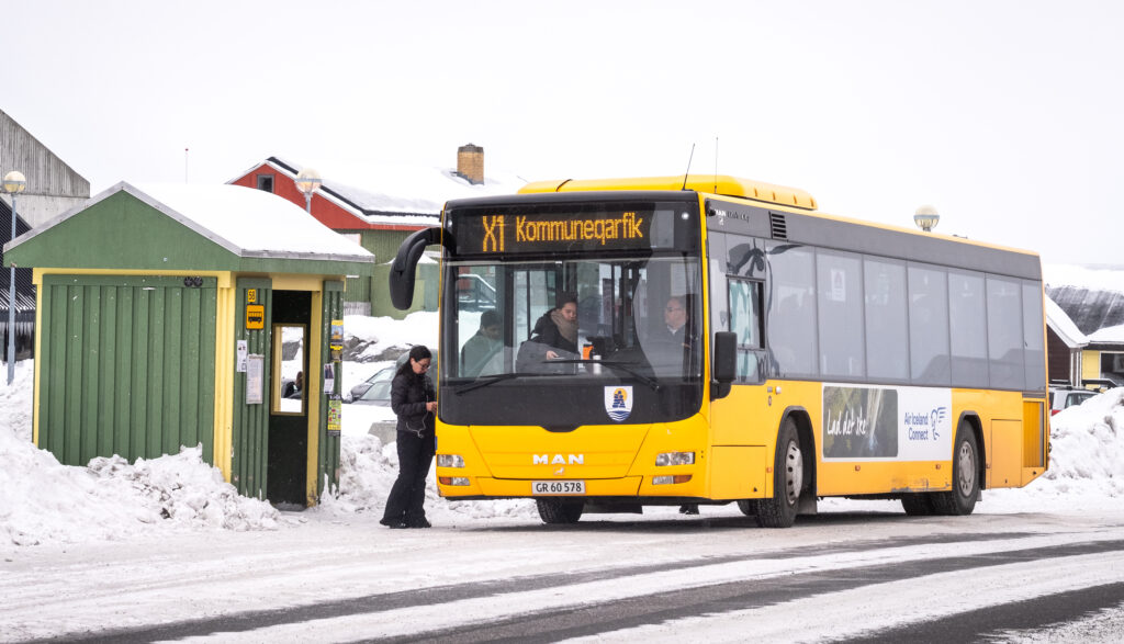 Passengers getting on a bus at a bus stop in Nuuk during winter - Greenland