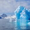 A large iceberg with mountains in the distance on a boat tour up the Nuuk Fjord with Guide to Greenland