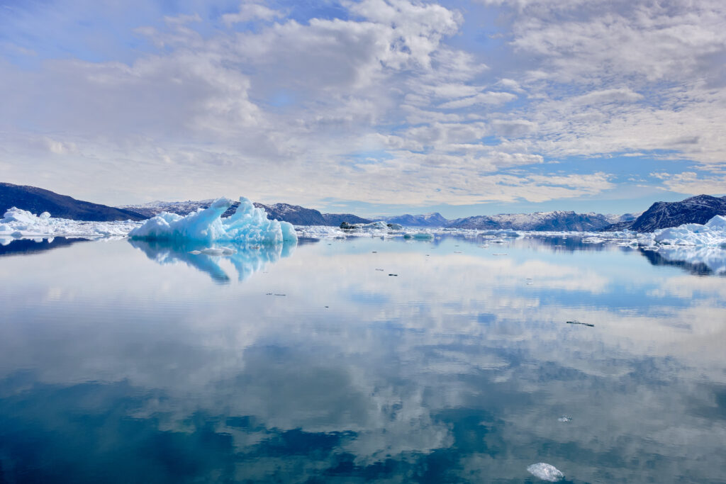 Sky and iceberg reflected in the water the Nuuk Icefjord on a boat tour with Guide to Greenland