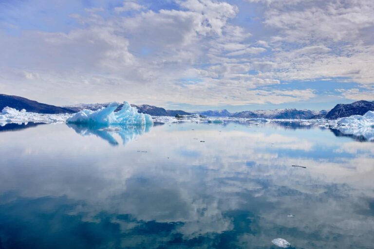Sky and iceberg reflected in the water the Nuuk Icefjord on a boat tour with Guide to Greenland