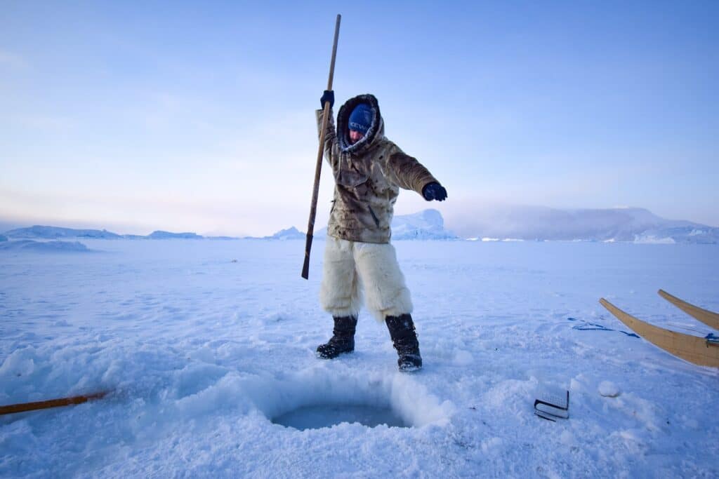 Breaking through the sea ice on an ice fishing excursion near Uummannaq - winter - Guide to Greenland