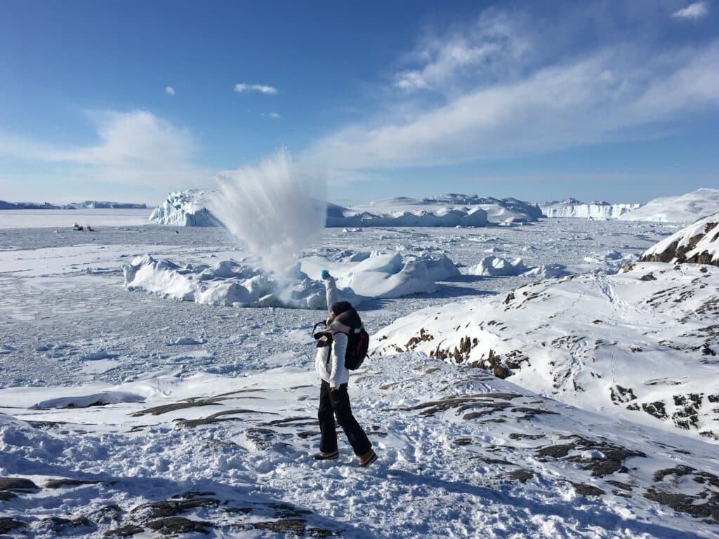 Gril trowing water that freezes instantly