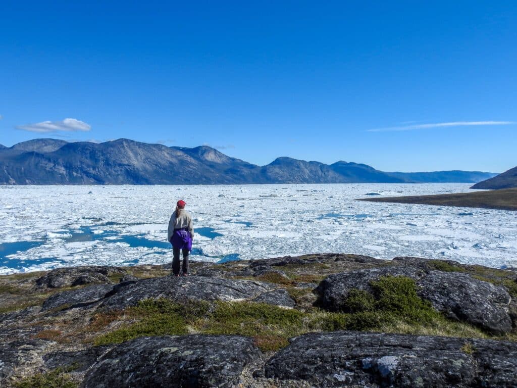 Woman overlooking the large amounts of ice in the fjord in Nuuk