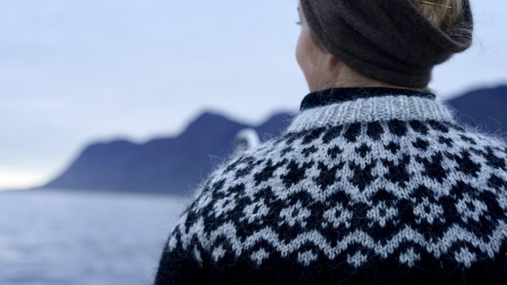 Woman in knit sweater trying to spot seals