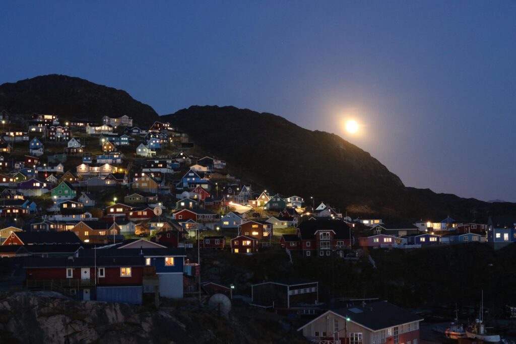 Moon over colorful houses in Qaqortoq