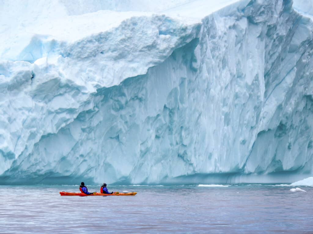 Kayaking near a large iceberg