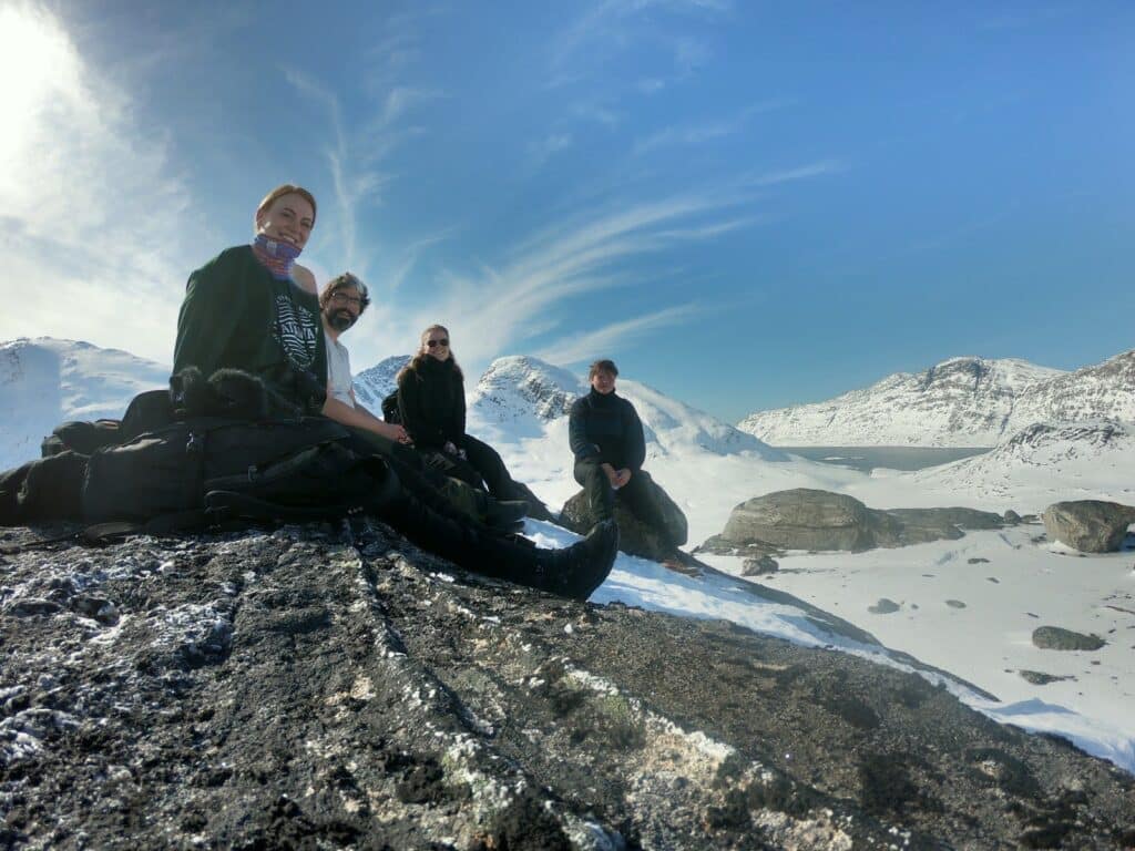 Four people eating lunch on a rock
