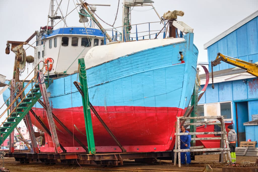 Blue and red ship at repair station in Aasiaat harbor
