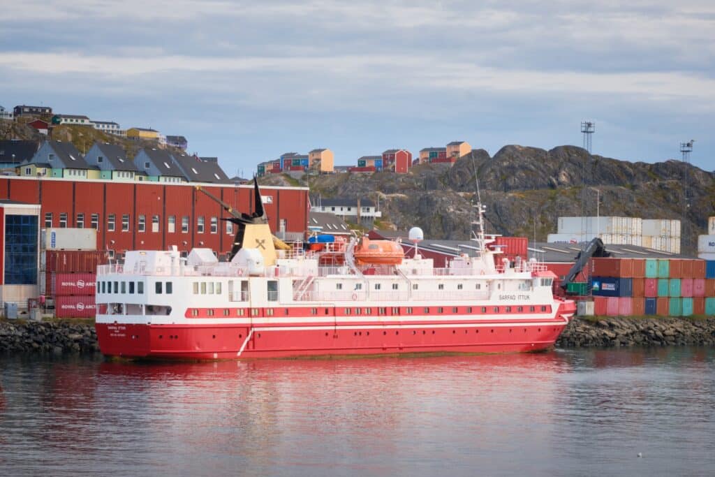 The red Sarfaq Ittuk passenger ferry at dock in the habour in Sisimiut