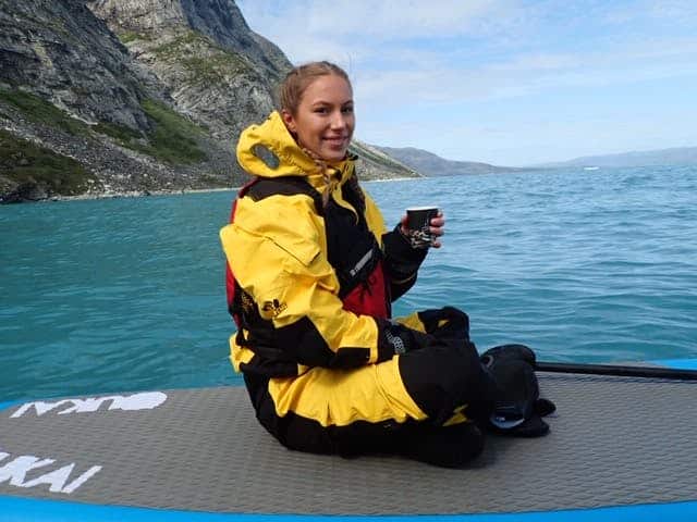Girl haveing a break while paddleboarding on the icefjord