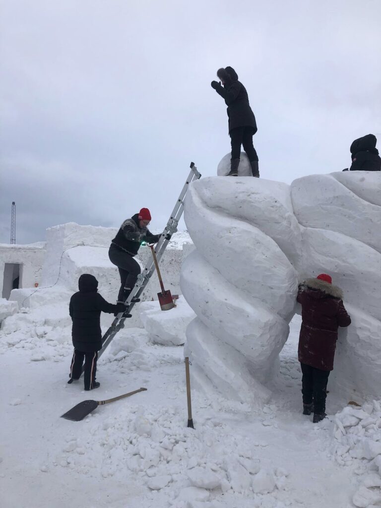 People working on a snow sculpture