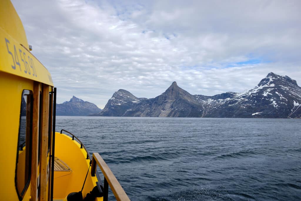 boat tour on the nuuk fjord heading towards qooqqut on a cloudy day - summer - guide to greenland