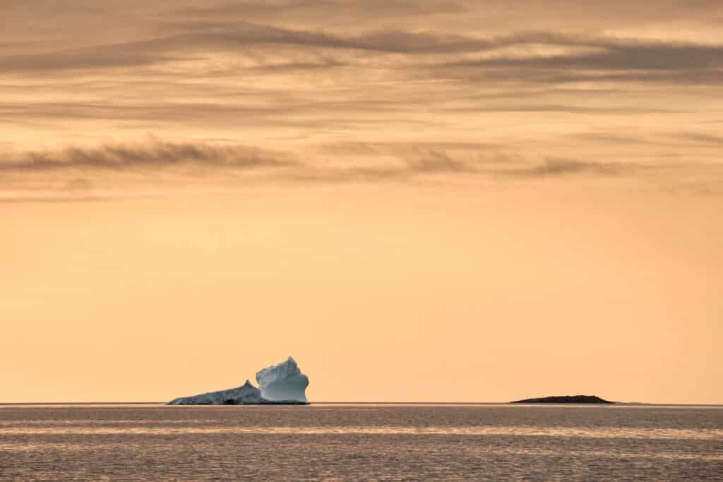 Enormous icebergs against a sunset near Aasiaat