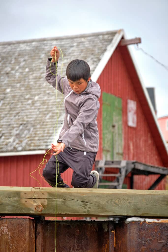 Kids fishing from the dock at Akunnaaq near Aasiaat