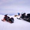 Snowmobilers and their machines at the viewpoint over Sisimiut