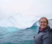 Girl-smiling-with-iceberg-in-background-Guide-to-Greenland Girl-smiling-with-iceberg-in-background-Guide-to-Greenland