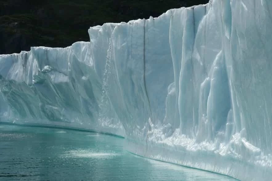 Enormous icebergs with a small waterfall in the South of Greenland