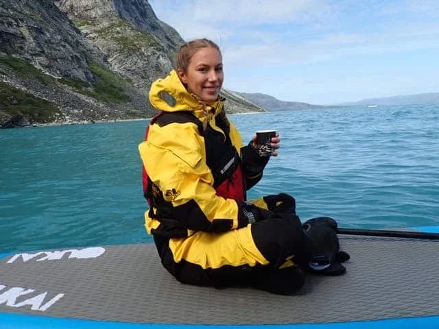 Girl haveing a break while paddleboarding on the icefjord
