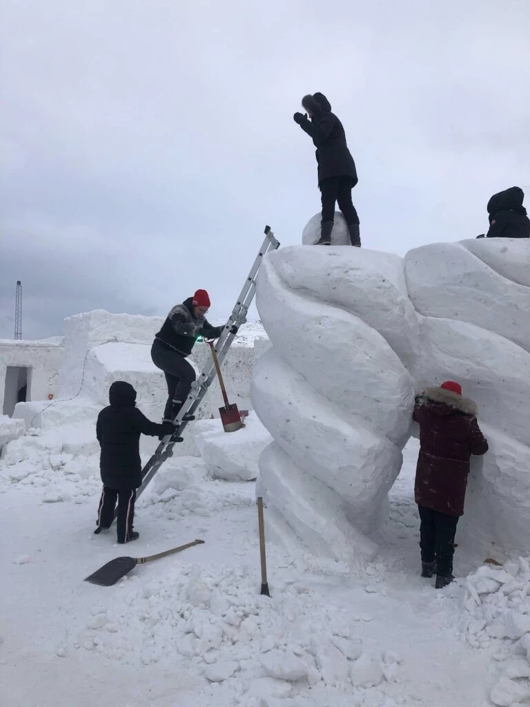 People working on a snow sculpture