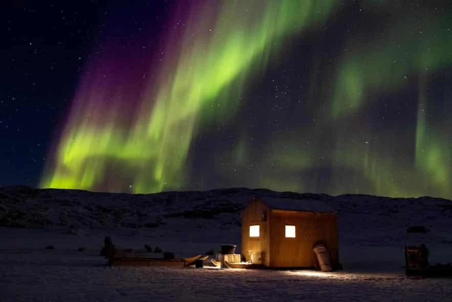 Nordlys over en lille hytte mellem Uummannaq og Ikerasak