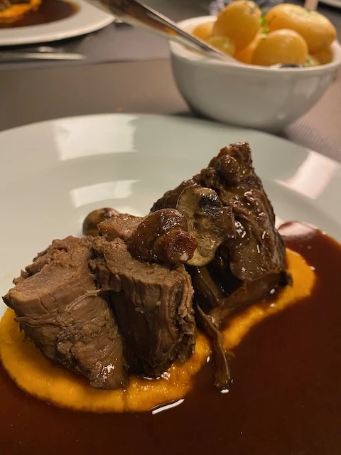 Eksempel på hovedret; braiseret rensdyrkølle med gulerodspuré og sorte bær sauce
